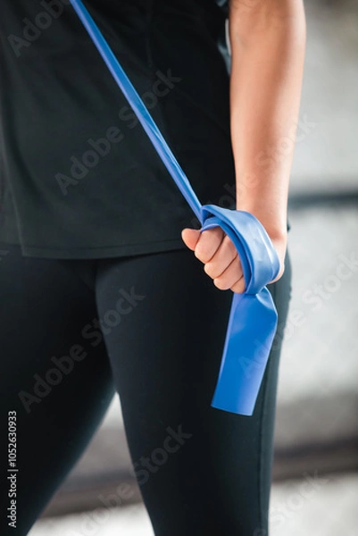 Fototapeta Sporty young woman with stretching band training at home, closeup