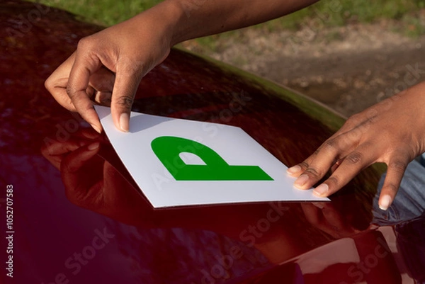 Obraz Hampshire England UK. 27.10.2024. Advisory gree P plate being positioned on car bonnet. Test pass withinn one year, a new driver.