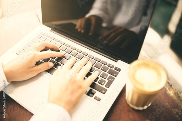 Obraz Man hands typing in laptop and cup of coffee on wooden table