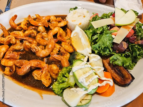 Fototapeta A plate of food with shrimp, broccoli, and carrots. The plate is white and the food is colorful