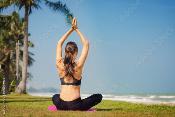 Obraz Молодая женщина занимается йогой на берегу моря