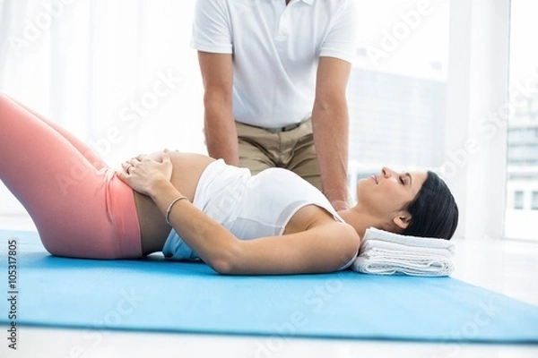 Obraz Doctor giving physiotherapy to pregnant woman