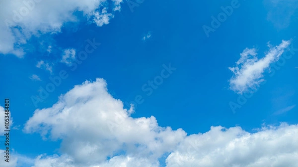 Obraz Bright Blue Sky with Scattered White Clouds
, creating a calm and serene atmosphere, perfect for representing clear weather and peaceful outdoor scenery.
