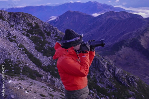 Fototapeta 山頂で朝日を撮影する男性登山者