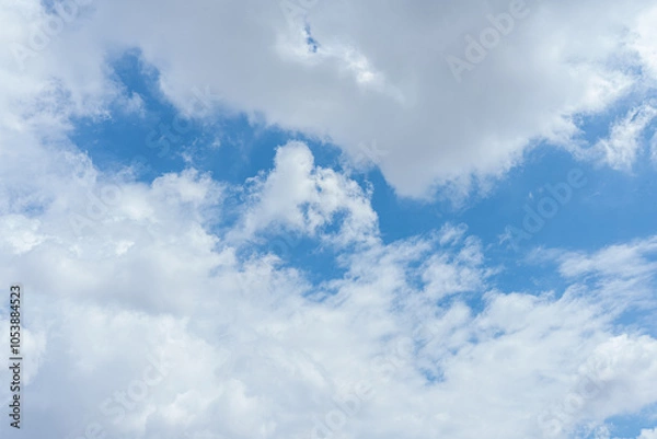 Fototapeta Blue sky dotted with fluffy white clouds