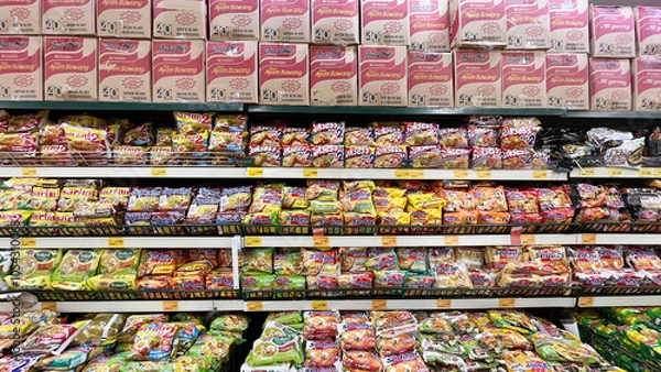 Fototapeta Jakarta, October 26, 2024: Grocery store shelves with instant noodles in a market in Jakarta, Indonesia. Variety brand of instant foods product on shelf rack display in a grocery store supermarket
