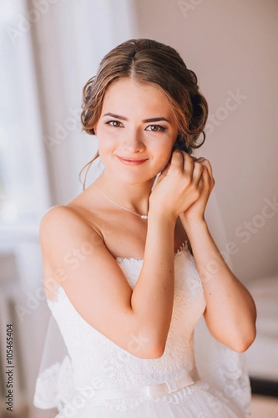 Fototapeta beautiful brunette stylish bride getting ready in the morning in the room