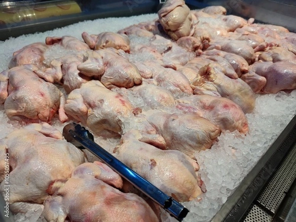 Fototapeta Fresh chickens displayed on ice in a supermarket. Perfect for roasting or grilling, ensures quality and freshness. Ideal for advertising, menus, or culinary blogs, highlighting premium meat