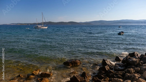 Obraz Adriatic Sea with a boat on the left and rocky shoreline on the right