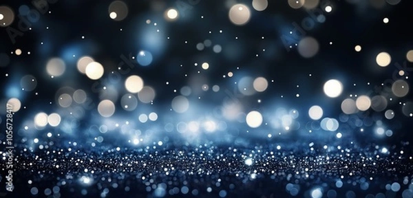 Fototapeta An abstract background featuring de-focused glittering blue and silver lights, softly glowing against a deep navy backdrop. 