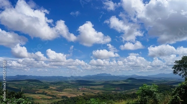 Fototapeta The allure of a landscape filled with the beauty of blue sky, fluffy white clouds, majestic high mountains, and vibrant green plants. Generative AI