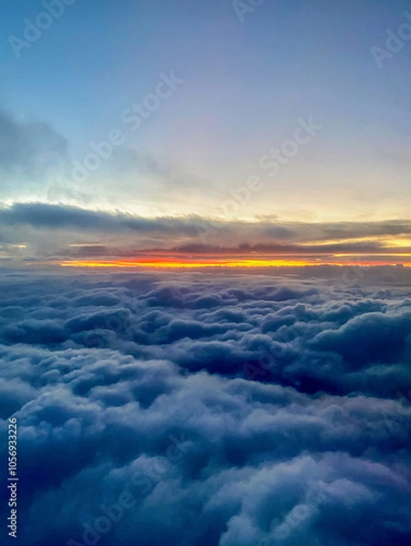 Fototapeta Sunset above the clouds, view from the window of an airplane