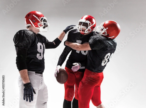 Fototapeta The three american football players posing on white background