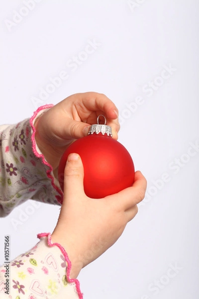 Obraz Kind hält eine Christbaumkugel