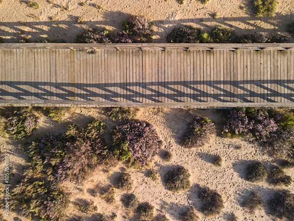 Fototapeta Top-down view of the wooden boardwalk for walking across sand dunes in Algarve