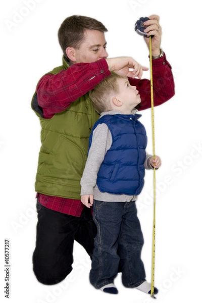 Fototapeta Father measuring son with a measuring tape
