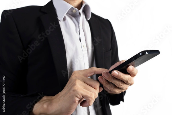 Fototapeta Businessman in black suit standing holding mobile phone to view work data and check work