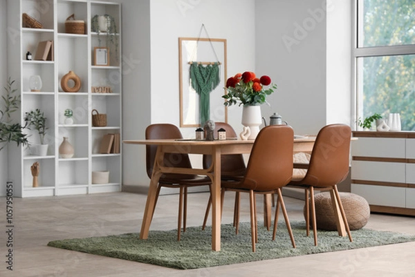 Fototapeta Dining table with dahlia flowers in vase in room