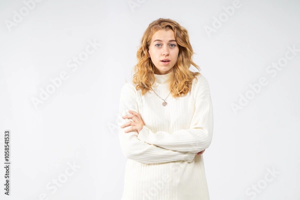 Fototapeta Surprised blonde girl on white background, waist-up portrait, copy space