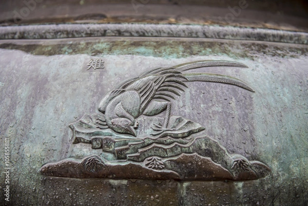 Fototapeta Metal relief of a bird, like a crow,  on of the Nine Dynastic Ur