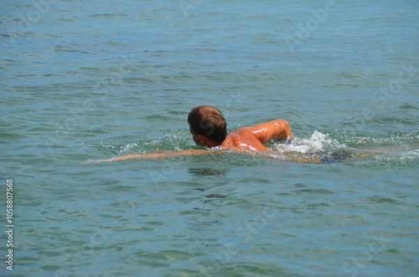 Obraz A guy swims into the sea with a breaststroke.