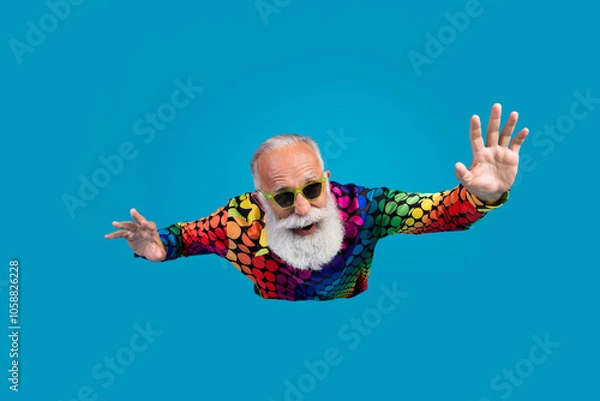 Obraz Portrait of funny extravagant aged man flying fall wear shirt isolated on blue color background