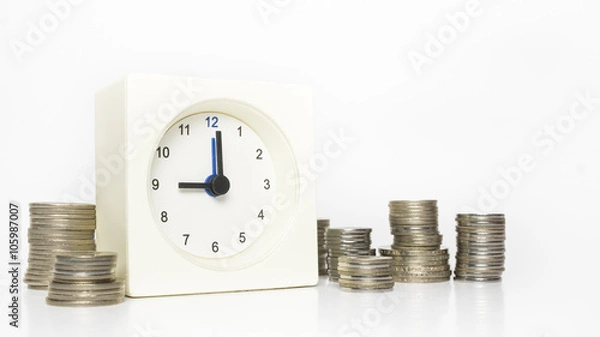 Fototapeta Table clock and multiple stacks of coins. Tme and money concept