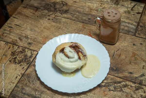 Fototapeta Waffle with vanilla cream and chocolate dips and chocolate drinks in white bottle, ice cream with white plate in a wooden dining table, desert caramel
