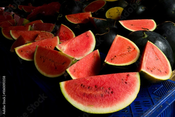Obraz des tranches de pasteques rouge vif avec l'ecorce verte sur l'etal d'un marchand sur un marché de rue