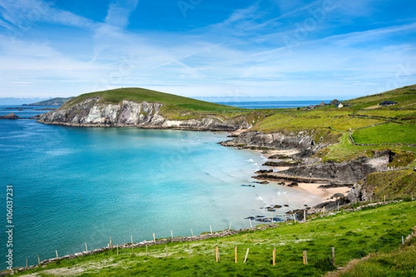 Fototapeta Ireland, Dingle, Slea Head: Coastal scene with panoramic ocean water view, bending coast line, green hill of Slea Head, horizon and blue sky in the background