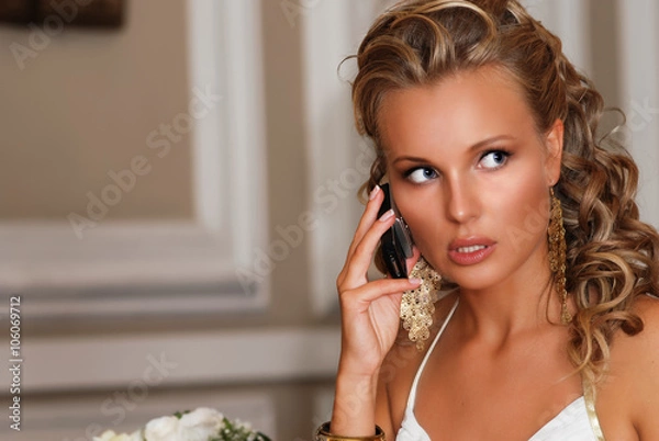Obraz Beautiful bride with mobile phone. Young woman speaking and worrying about something.