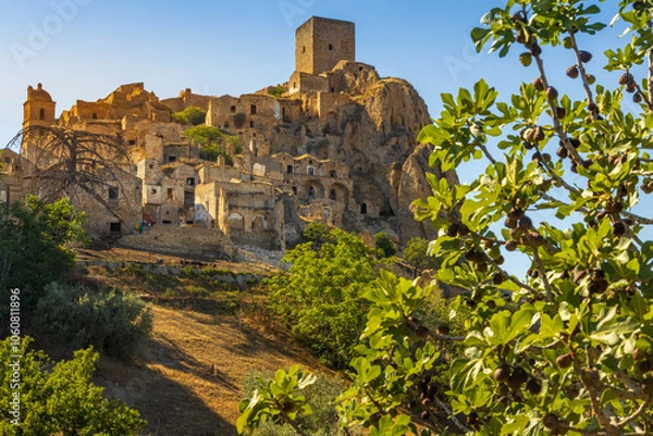 Fototapeta A picturesque view of the abandoned, old mountain town of Craco, built of sandstone rock. Craco is a ghost town abandoned due to an earthquake in the late 20th century. Province of Matera, Basilicata,