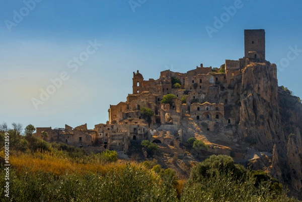 Fototapeta A picturesque view of the abandoned, old mountain town of Craco, built of sandstone rock. Craco is a ghost town abandoned due to an earthquake in the late 20th century. Province of Matera, Basilicata,