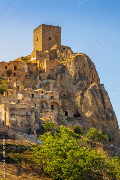 Fototapeta A picturesque view of the abandoned, old mountain town of Craco, built of sandstone rock. Craco is a ghost town abandoned due to an earthquake in the late 20th century. Province of Matera, Basilicata,