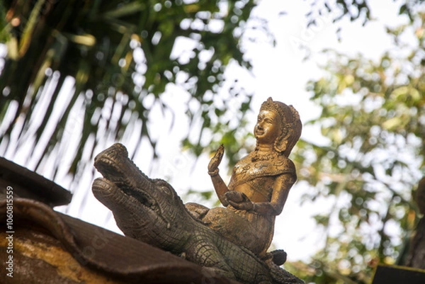 Fototapeta goddess dharani mata on crocodile, old golden statue, temple in thailand