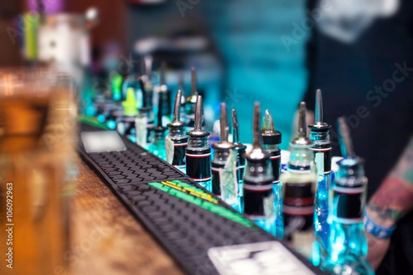 Obraz Many bottles with alcoholic beverages on the bar counter 