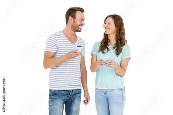 Fototapeta Happy young couple text messaging on mobile phone