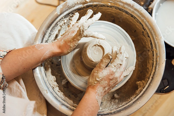 Fototapeta Cropped shot of unrecognizable child making ceramic mug at pottery class