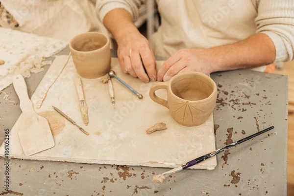 Fototapeta Cropped shot of unrecognizable child making ceramic mug at pottery class