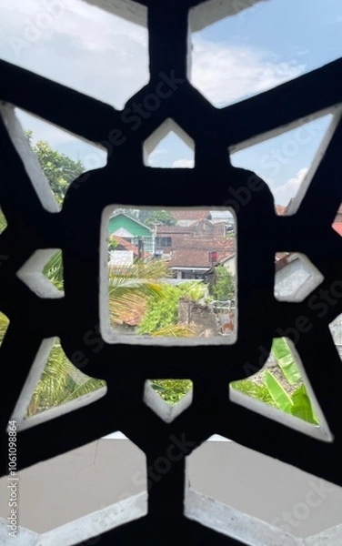 Obraz A window with a black frame and a white background. The window is open and the view is of a city