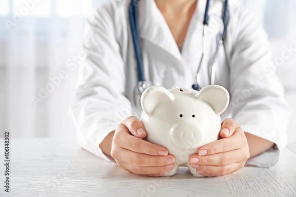 Obraz Doctor hands with piggy bank closeup