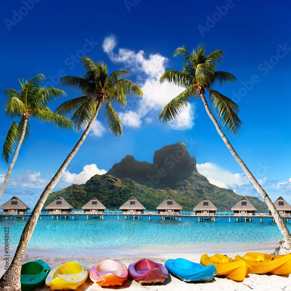Obraz  Otemanu  mountain, inclined palm trees over the sea and bright canoes on the beach. Island  Bora Bora, Tahiti.