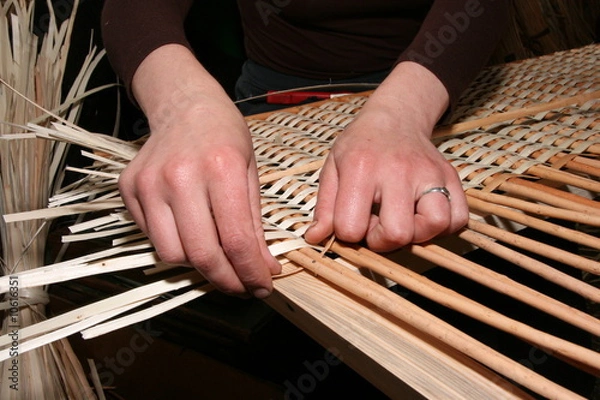 Fototapeta Female hands manually mastering wicker fabric