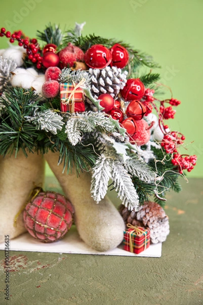Fototapeta Christmas composition with pine needles and red decorations in felt boots