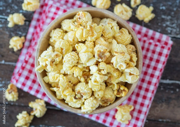 Fototapeta popcorn in brown bowl on dark wooden table.