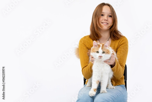 Fototapeta A Cheerful Girl Holding a Sweet Cat in a Cozy Studio Setting Filled with Joy and Warmth