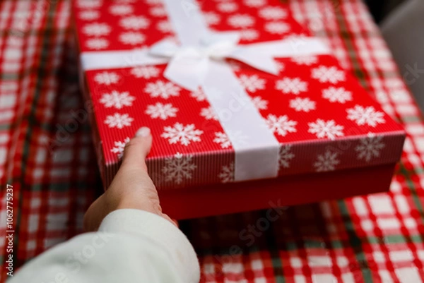 Fototapeta Hand hold gift box on a red backgroung 