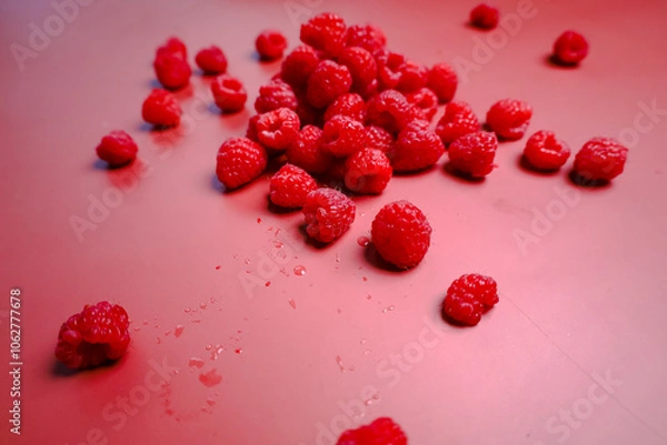 Fototapeta Side view to the fresh raspberry at the red background