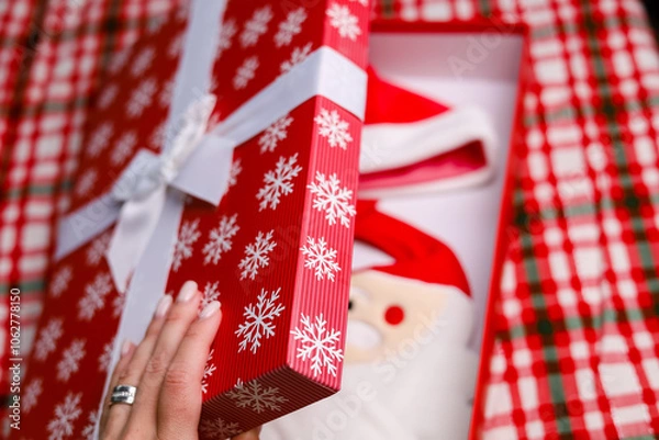 Fototapeta Hand open Christmas gift box on a red backgroung 