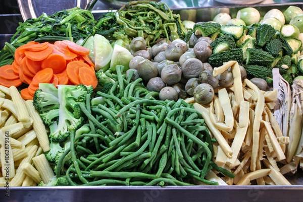 Fototapeta Boiled vegetables sold in the market include thinly sliced ​​carrots, broccoli, baby corn, green beans, bamboo shoots, bitter melon, and eggplant, which are all healthy vegetables.